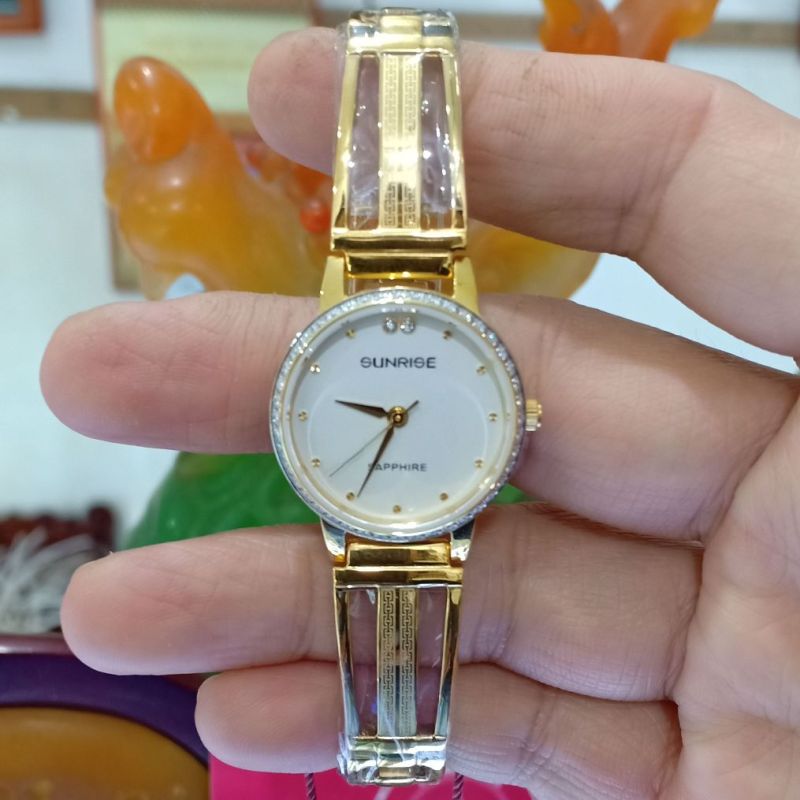 Đồng hồ lắc tay nữ SUNRISE 9924AA dây vàng mặt trắng, viền đính đá thời trang, kính sapphire chống xước, chống nước tốt.