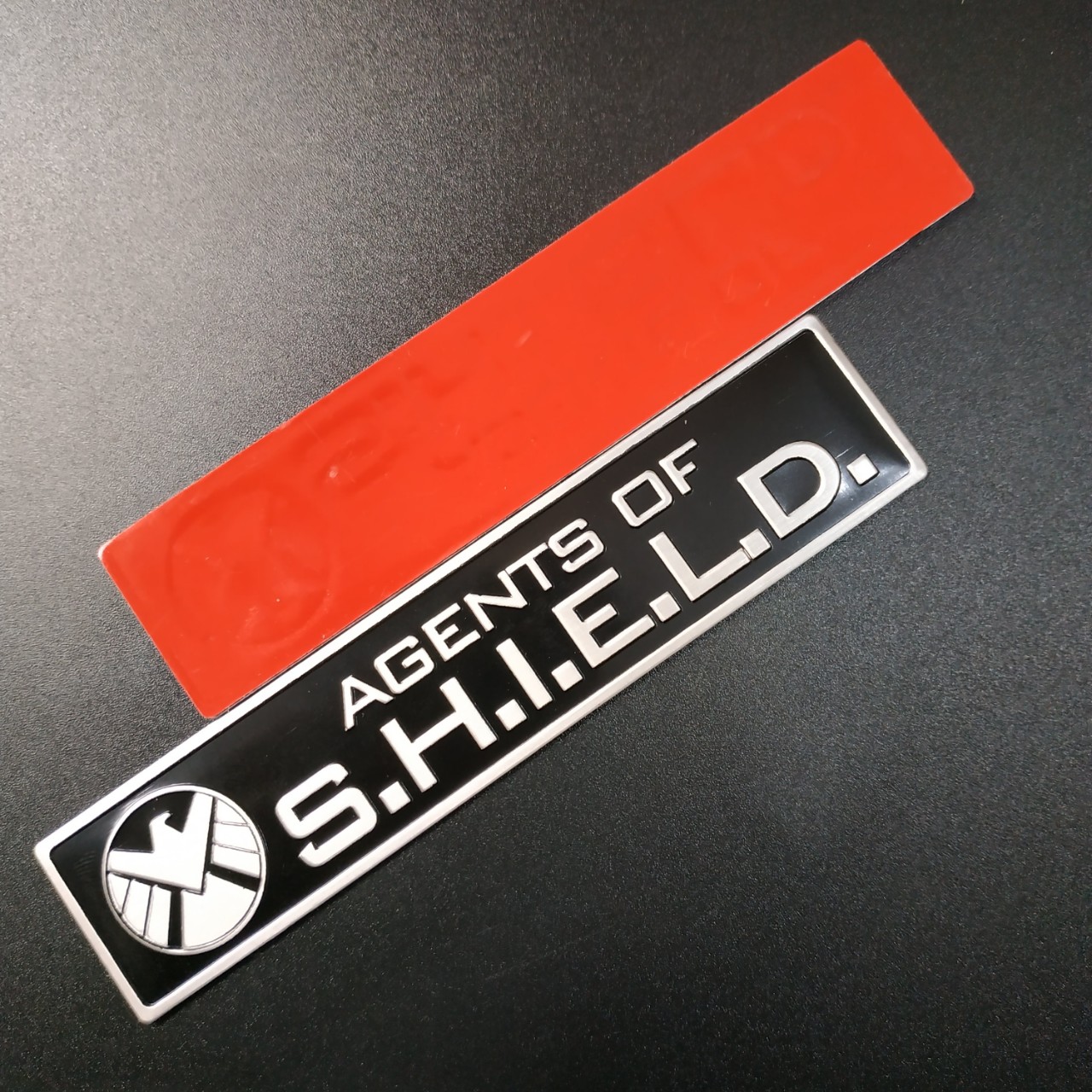 Tem nhôm dán xe SHIELD dài 12x2.6cm nền đen