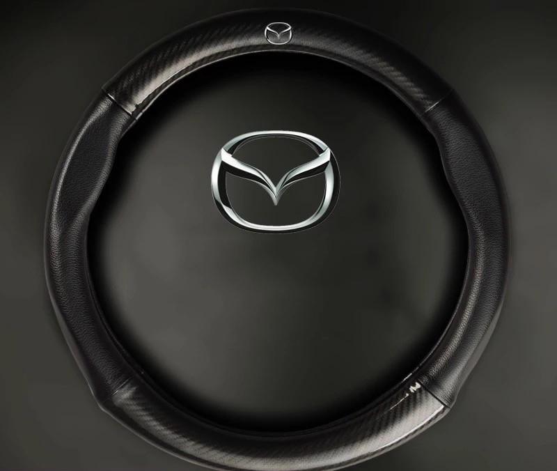 Bọc vô lăng, bọc tay lái, bọc da vô lăng cao cấp mẫu Carbon có đính kèm logo MAZDA màu đen, chất liệu da dày dặn thiết kế bắt mắt Giúp bảo vệ bọc vô lăng nguyên bản một cách tối ưu