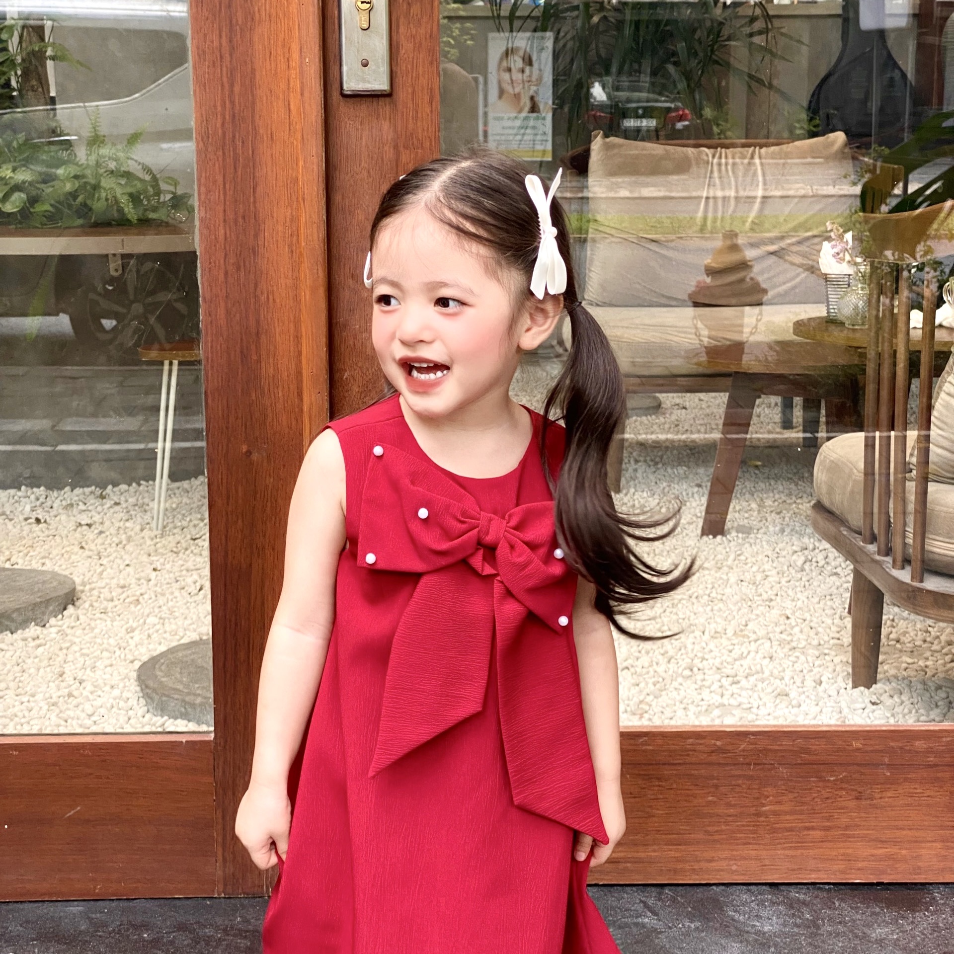 Đầm dáng A đính nơ , đính nút ngọc cho bé