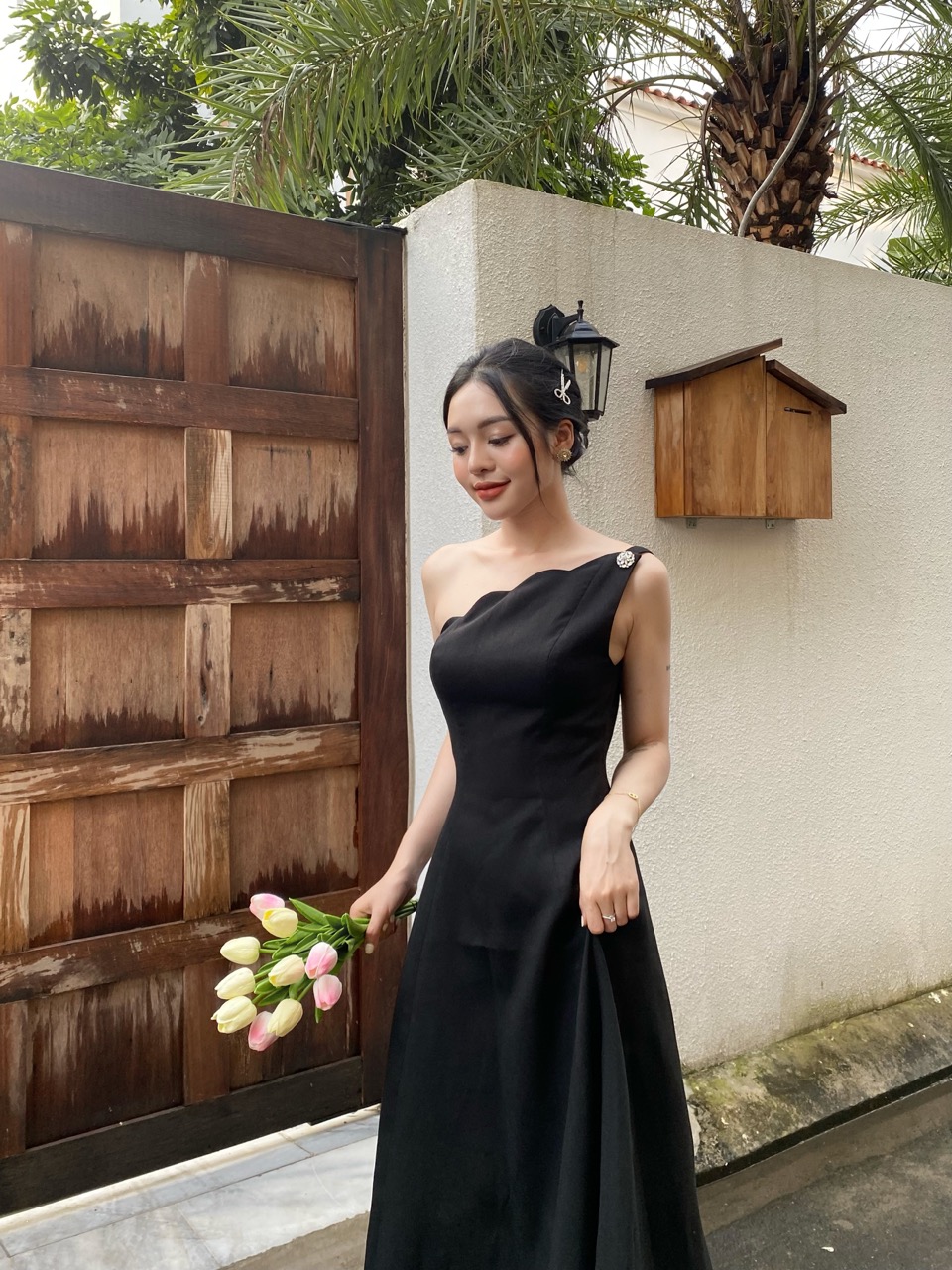 COCO SIN - Đầm Tapta Đen Lệch Vai Đính Nút Hoa