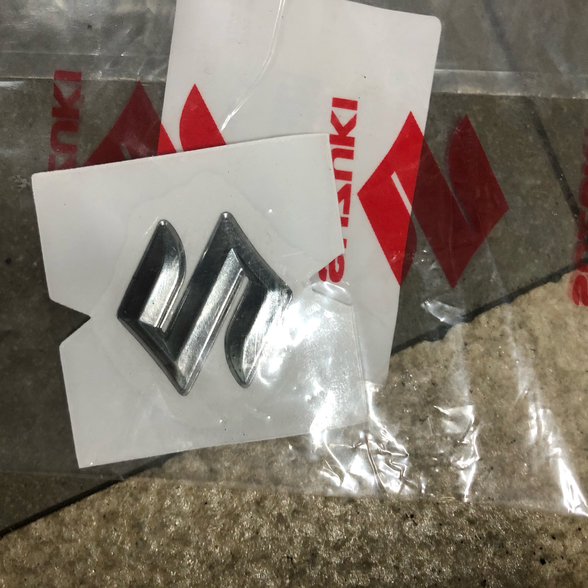 Tem chử nổi logo chữ S gắn chắn gió Satria Raider Fi Chính hãng indo