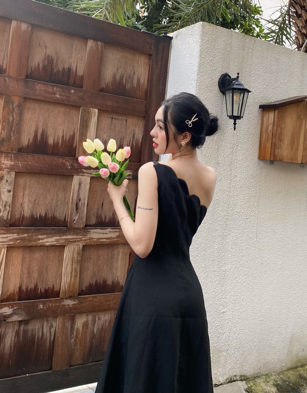 COCO SIN - Đầm Tapta Đen Lệch Vai Đính Nút Hoa