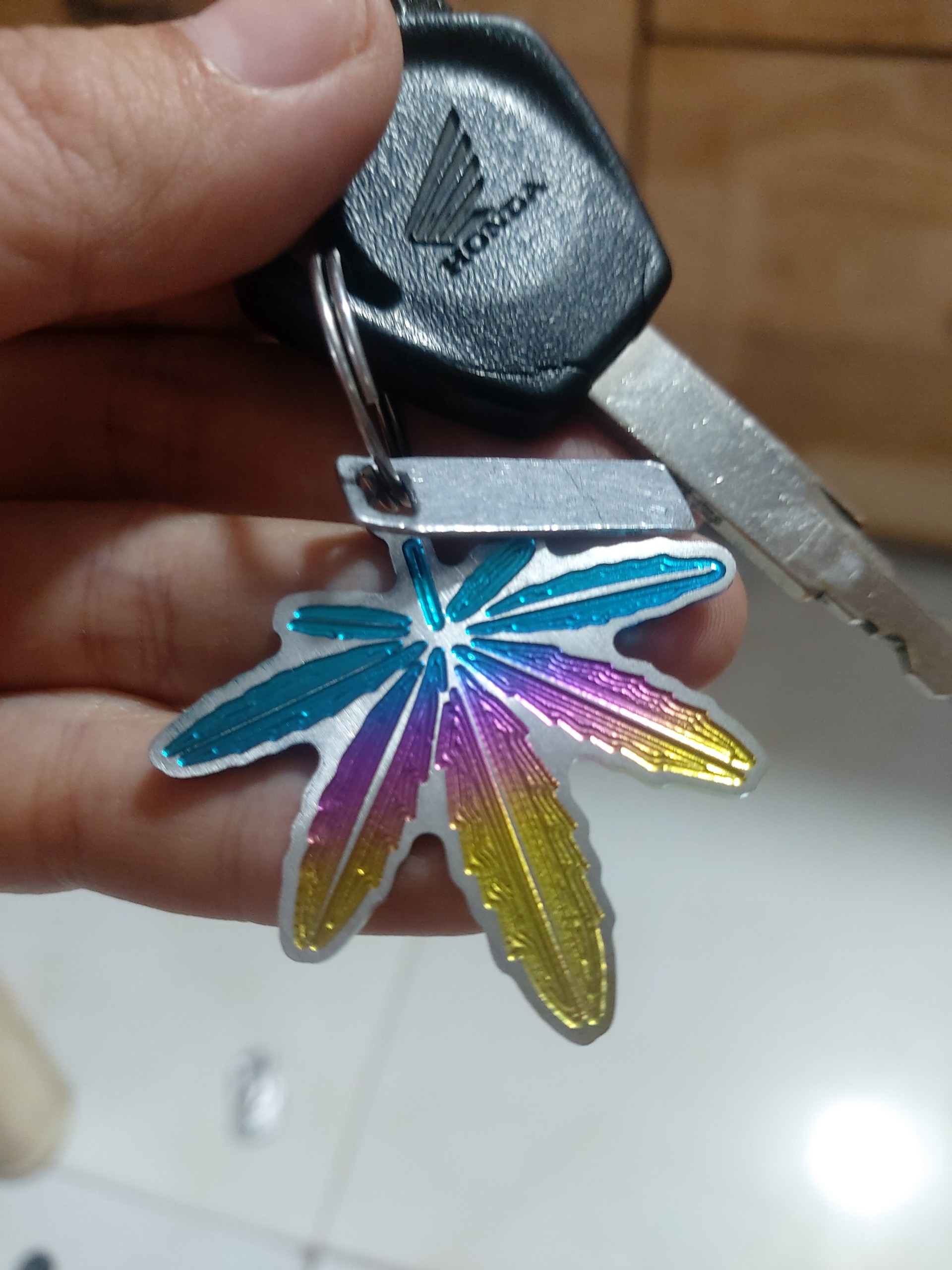 Móc khóa logo sticker chiếc lá titan 7 màu siêu đẹp