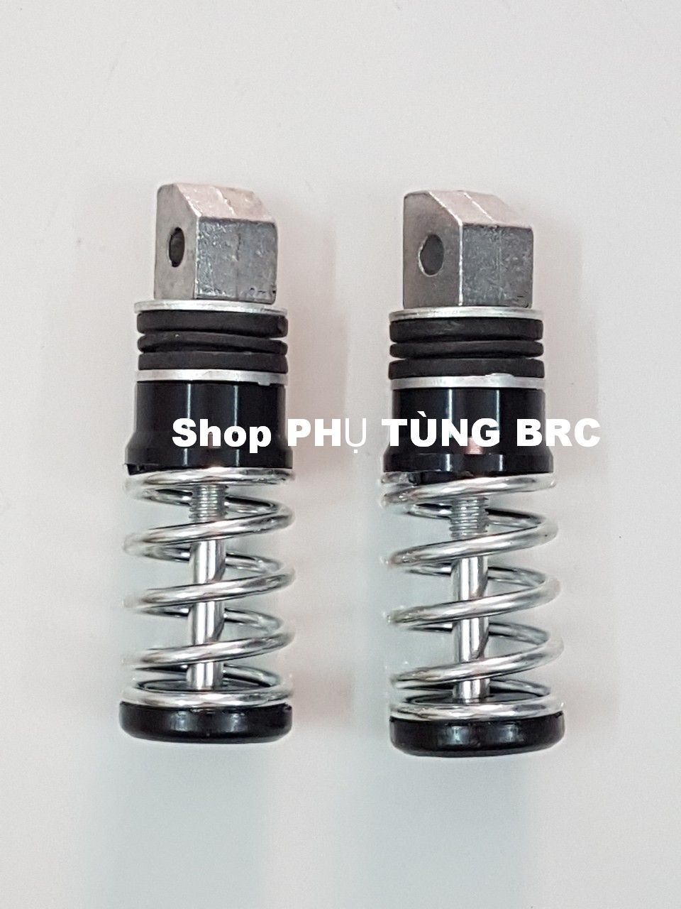 Gác chân sau lò xo xe máy ( 1 đôi, tặng 2 con ốc kiểu để lắp).