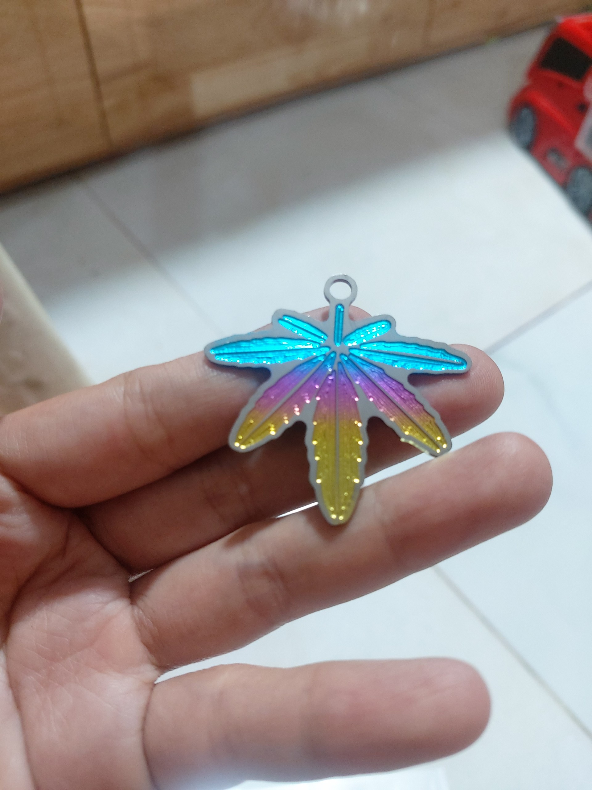 móc khóa logo sticker chiếc lá titan 7 màu siêu đẹp