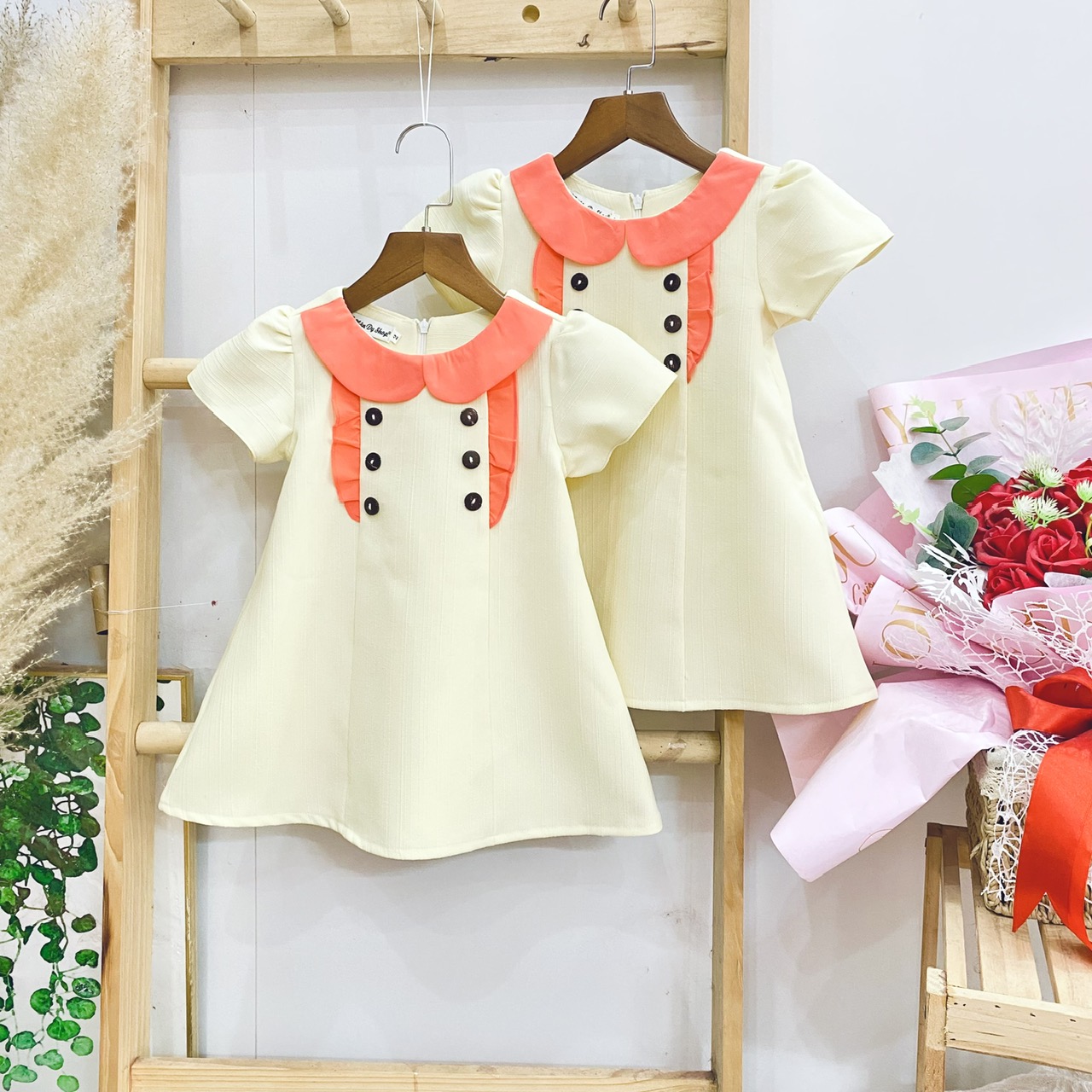 Đầm A cổ sen đính nút ngắn tay cho bé