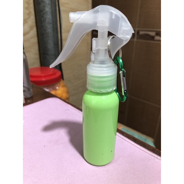 Compact 60ml water bottle with integrated keychain for hand sanitizer.