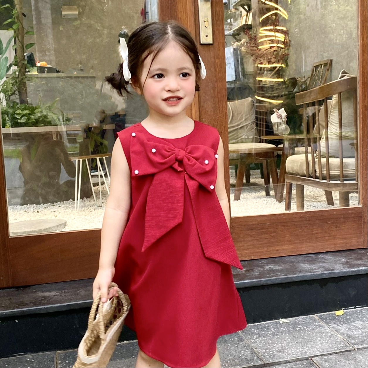 Đầm dáng A đính nơ , đính nút ngọc cho bé