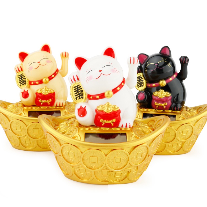 Chú mèo may mắn ngồi trên thỏi vàng